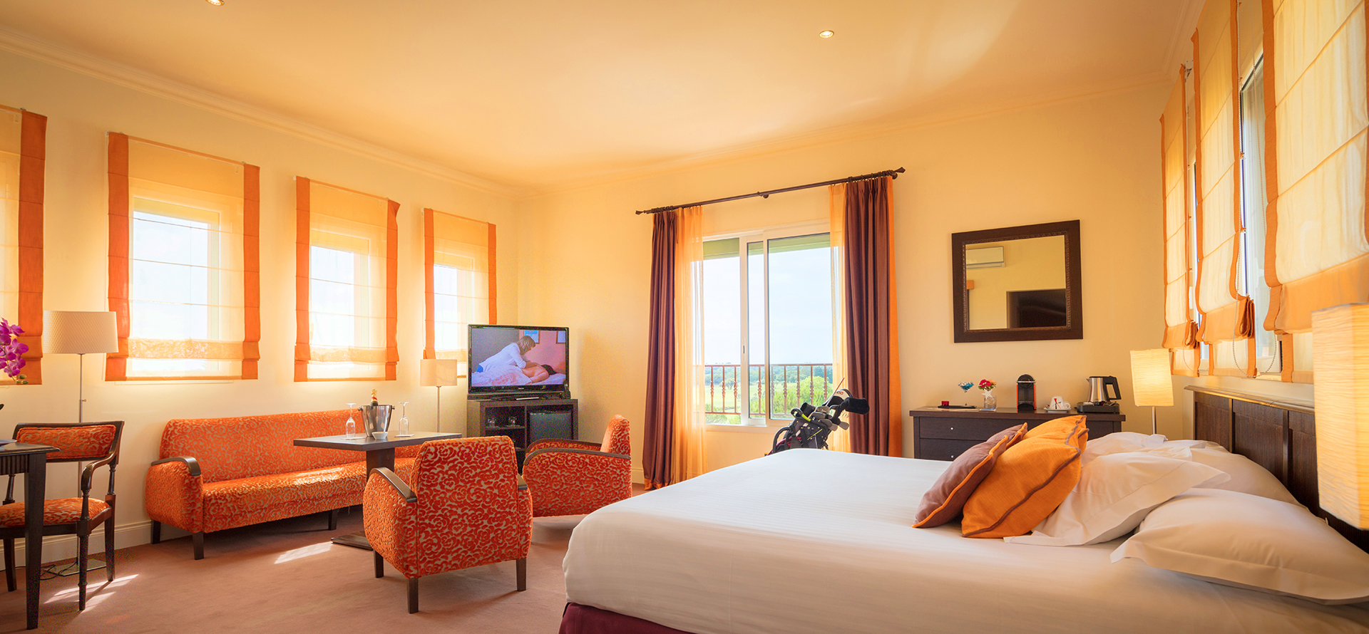 Saloncito de una suite del Palmyra Golf Hotel con vistas al golf internacional en Occitania